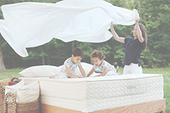 Family playing on an organic mattress from Savvy Rest