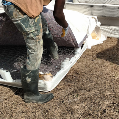 a man tears apart a post-consumer mattress for recycling