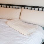 Folded organic cotton blanket on bed.