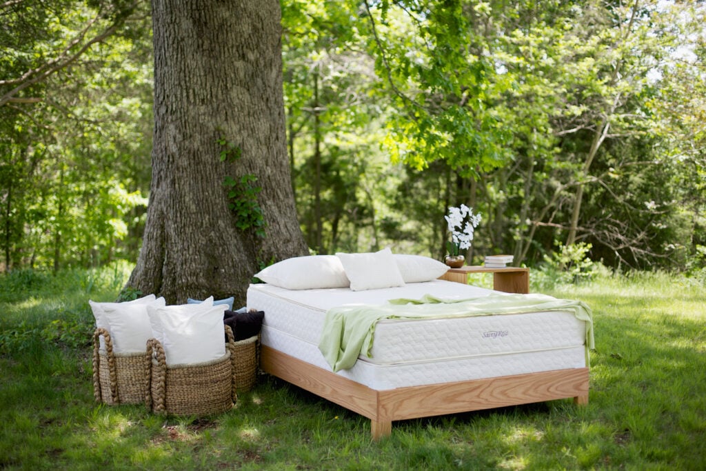 Savvy Rest Serenity organic mattress on a wooden platform bed outdoors