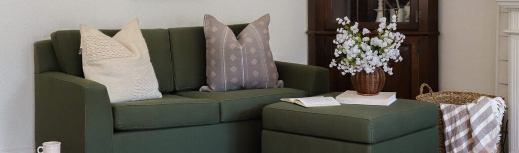 Green organic sofa with throw pillows in a living room