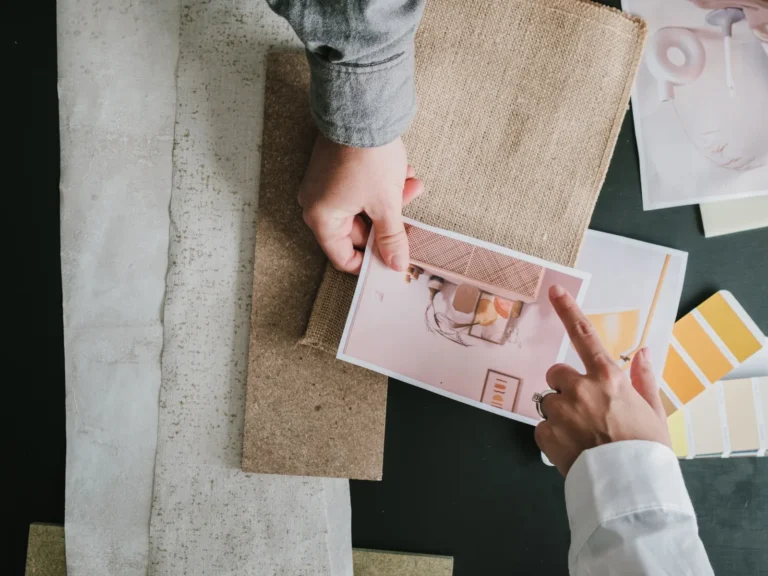 Hands comparing fabric swatches, paint colors and interior design photos