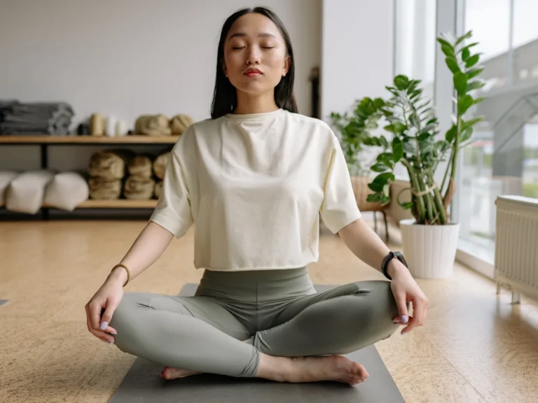 Woman meditating in a sunlit wellness studio